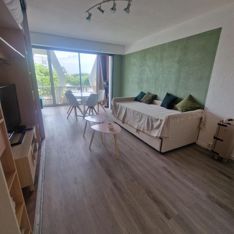 - une chambre avec un lit et une table ainsi qu'une chambre avec une télévision dans l'établissement TypeT1 Spacieux à 300m du port et 6min de la plage, à La Grande Motte