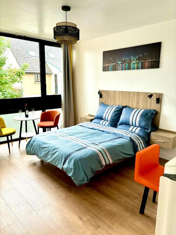 une chambre avec un lit, une table et des chaises dans l'établissement Appartement entier HUI, à Rueil-Malmaison