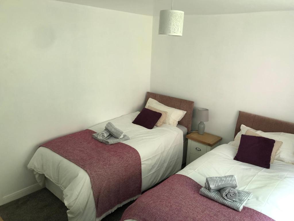 two beds in a small room with towels on them at Middle Cottage Alton Towers, Peak District, JCB in Croxden