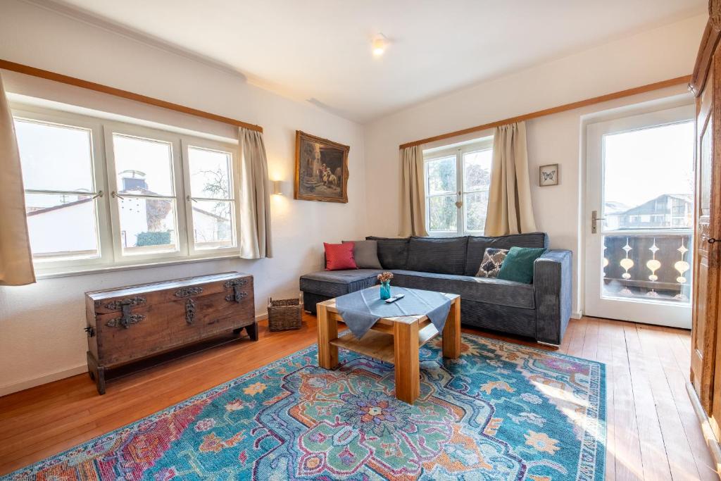 ein Wohnzimmer mit Sofa und Tisch in der Unterkunft AlpenPuls in Farchant