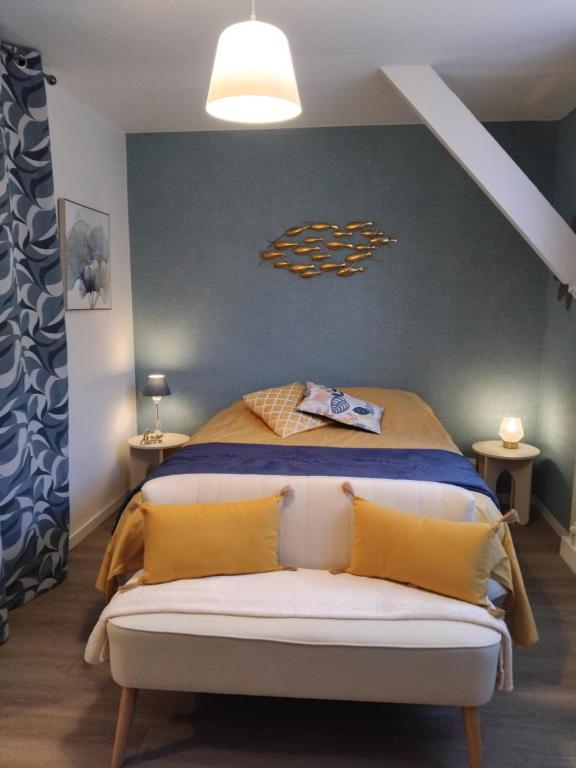 une chambre avec un lit avec des oreillers jaunes dans l'établissement Studio Mer et Centre équestre, à Mers-les-Bains