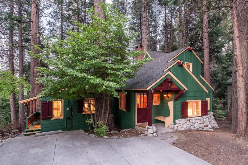 a green house in the middle of the forest at Contemporary Classic on a Private Mountain Lake in Lake Arrowhead