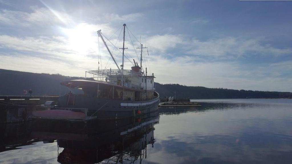 un barco está atracado en un muelle en el agua en Swept Away Inn, en Port Alberni