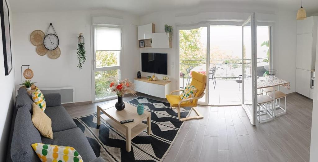 un salon avec un canapé et une table dans l'établissement Appartement classé 3 étoiles à 150m de la plage, à Fréjus