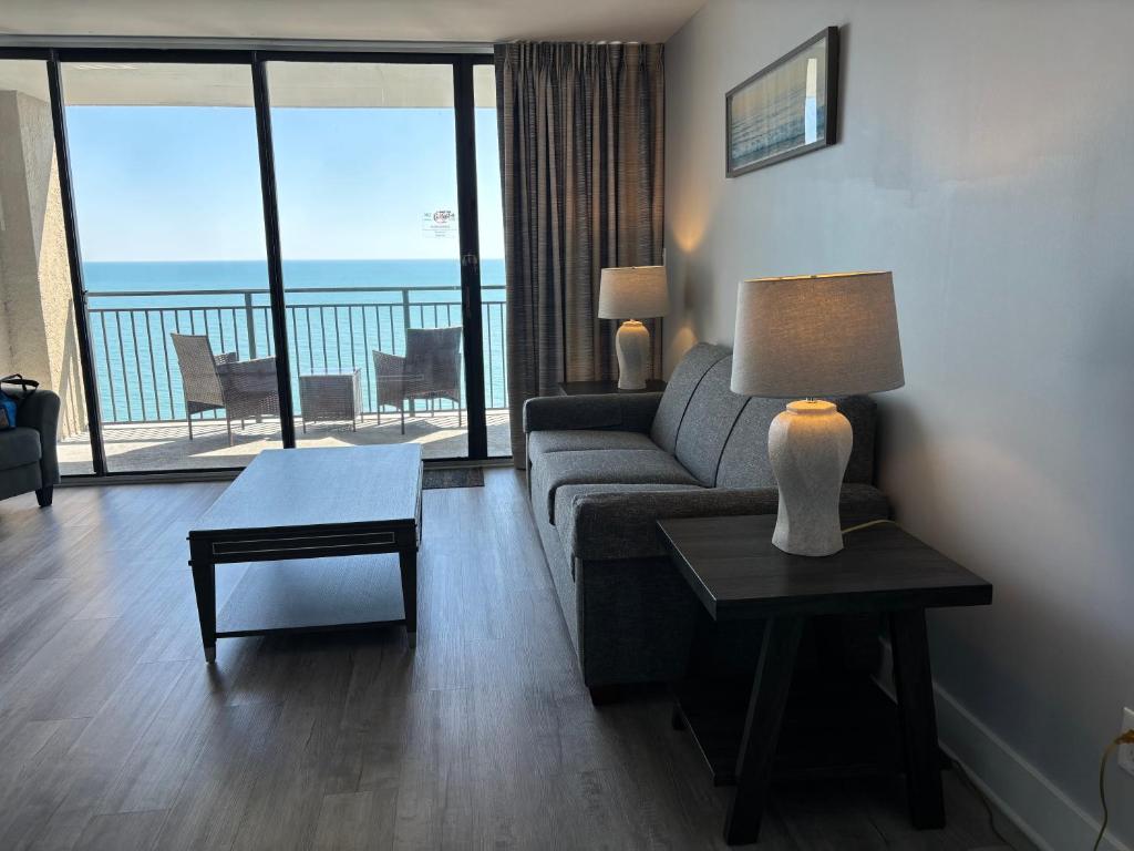 una sala de estar con un sofá y una mesa en Scenic Views from the balcony at Ocean Forest Plaza Condos, en Myrtle Beach
