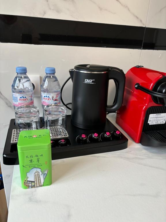 a coffee maker and water bottles on a counter at Appartement entier HUI in Rueil-Malmaison