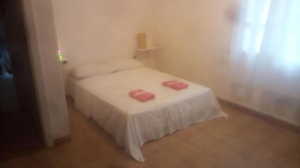 - une petite chambre avec un lit et 2 serviettes roses dans l'établissement Tubarao, à Búzios