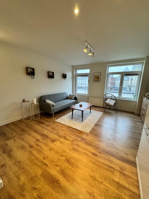een woonkamer met een bank en een tafel bij Grand Duplex avec 2 chambres in Charleroi