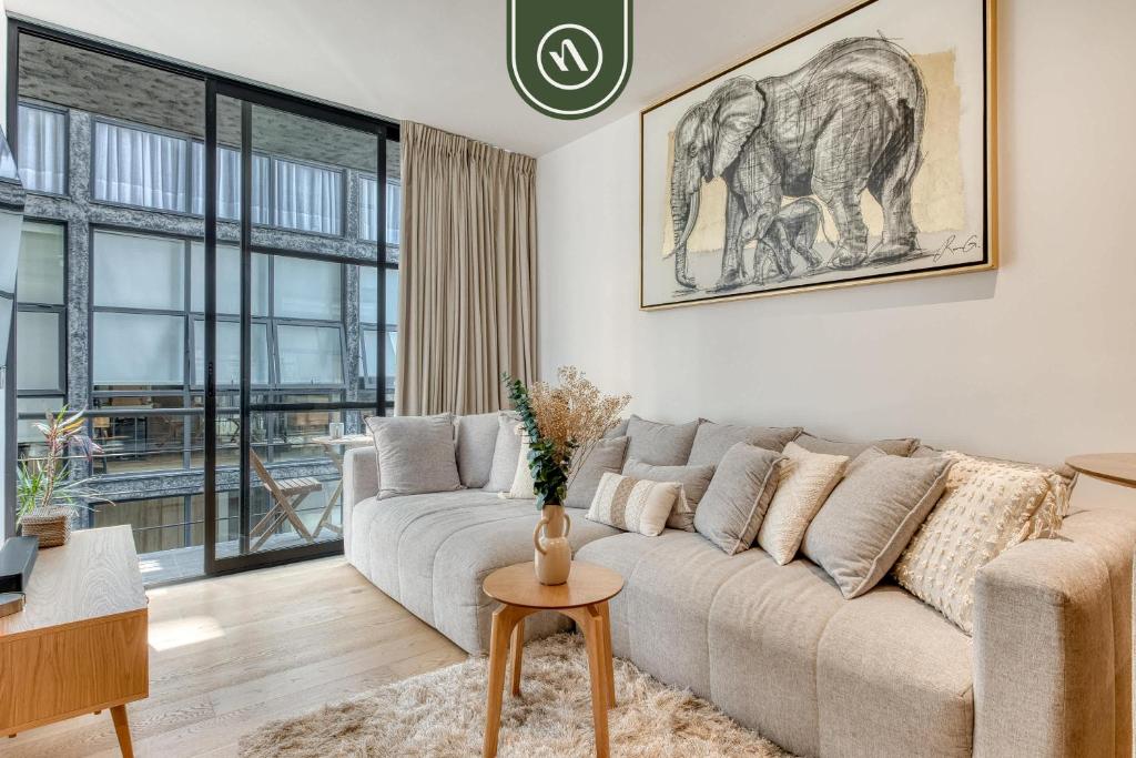 a living room with a couch and an elephant painting on the wall at Centric 2 BR Condo - Gym - Open Air Cinema in Mexico City