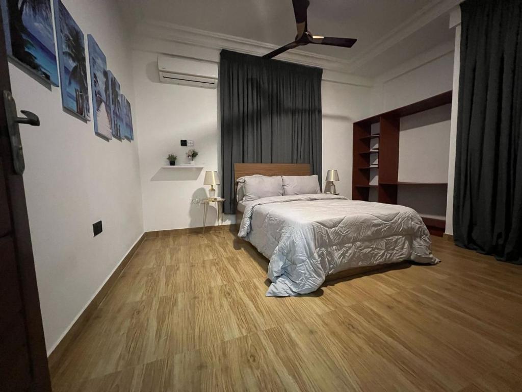 North LegonにあるFlintsky Residenceのベッドと木の床のある寝室