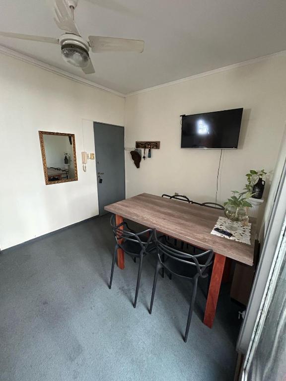 Zimmer mit einem Holztisch und einem TV an der Wand in der Unterkunft Departamento 1 dormitorio in Santa Fe