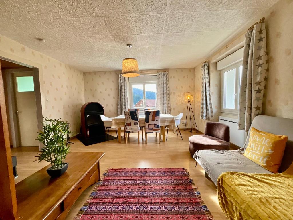 a living room with a couch and a table at Le Cresson, charmant et spacieux avec balcon in Gérardmer