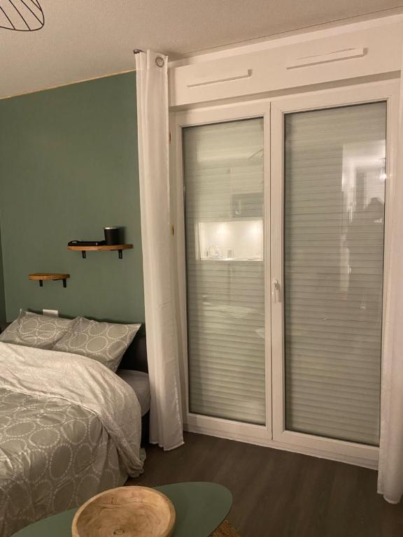 - une chambre avec un lit et une fenêtre avec des stores dans l'établissement Spacieux T2 boulevards au pied du tram C, à Bègles