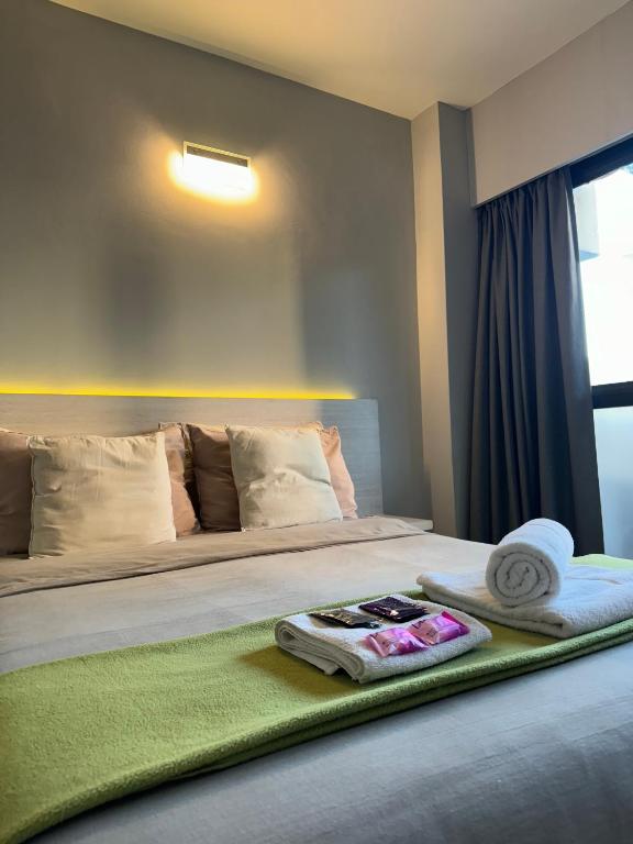 a hotel room with a bed with towels on it at Av Suites in Rosario