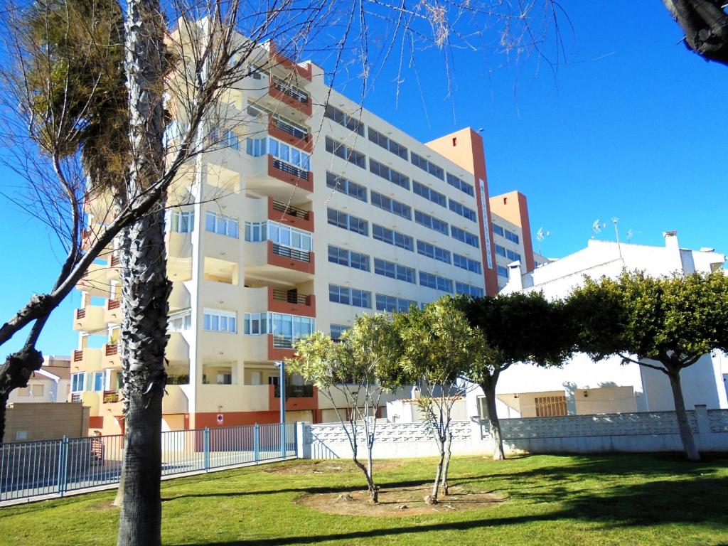 ein großes weißes Gebäude mit Bäumen davor in der Unterkunft Europeñiscola playavacaciones in Benicarló