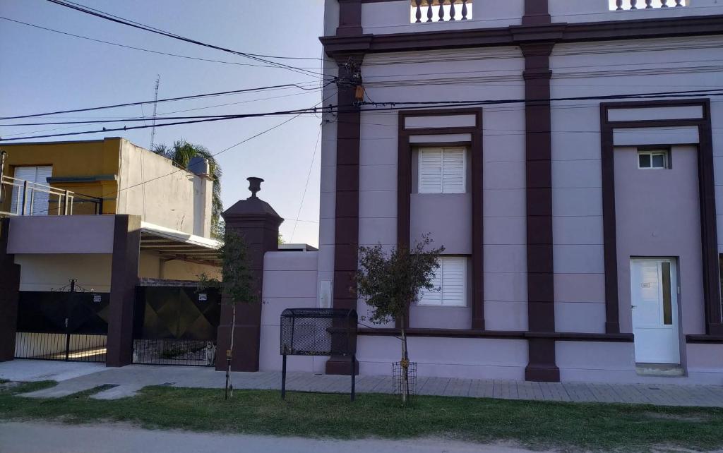 a white building with a clock tower on a street at Don Oscar Alojamientos Dpto Sol in San Justo