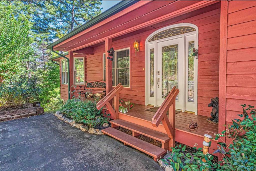 a red house with a porch with a bench on it at Mountain Peace in Townsend