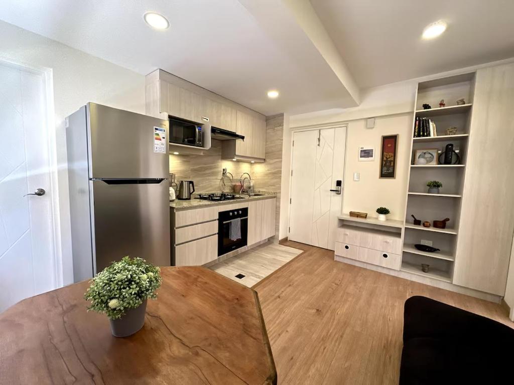 a kitchen with a table and a stainless steel refrigerator at Cozy smart studio & home office in La Paz