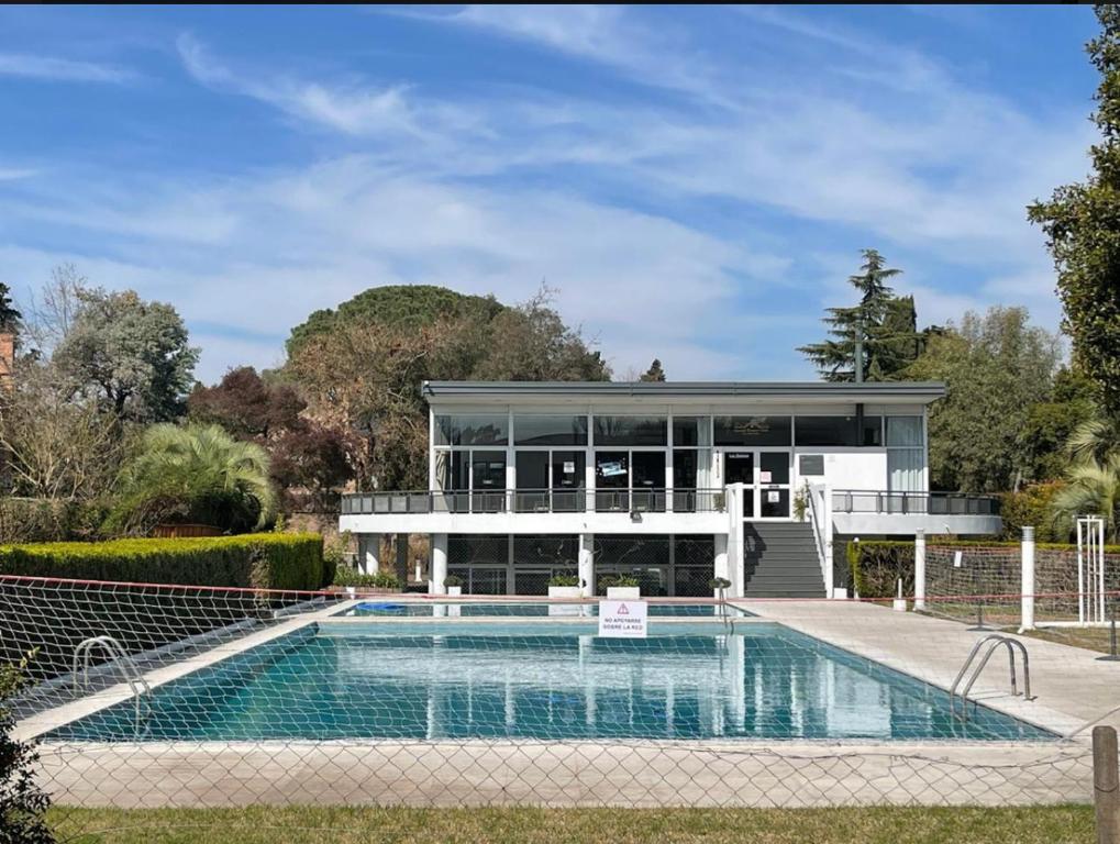 a house with a swimming pool and a building at Muy buen apartamento con parrilla y piscina, en country in Pilar