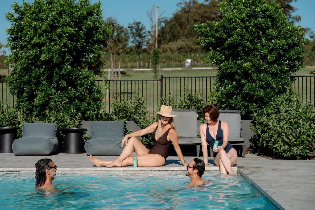 eine Gruppe von Frauen, die in einem Schwimmbad sitzen in der Unterkunft The Lane Retreat in Pokolbin