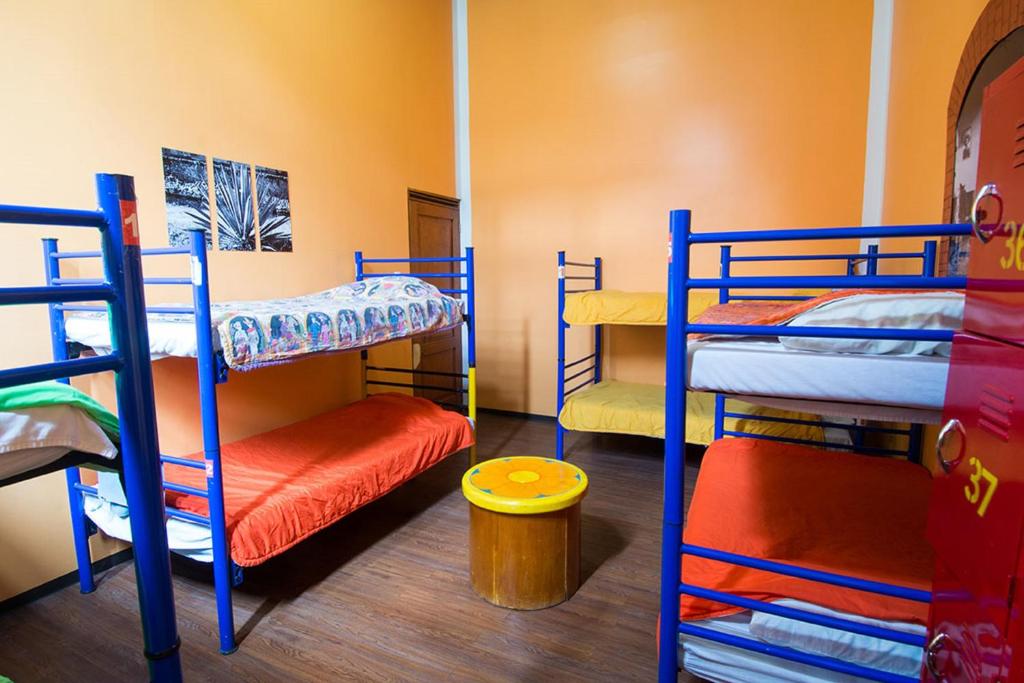 a room with three bunk beds in a room at Hostal Amigo in Mexico City