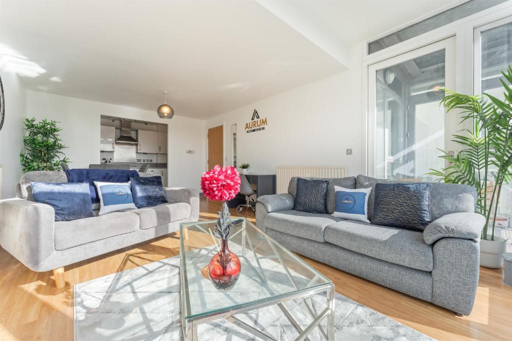 a living room with two couches and a glass table at Birmingham City Centre Sunset Park Free Parking in Birmingham