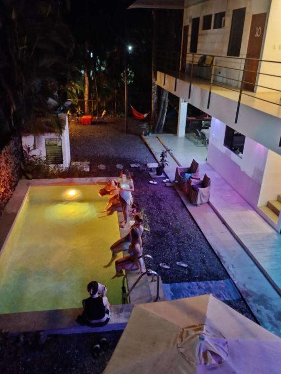 a group of people in a swimming pool at night at Casajungla Hostel in Jacó