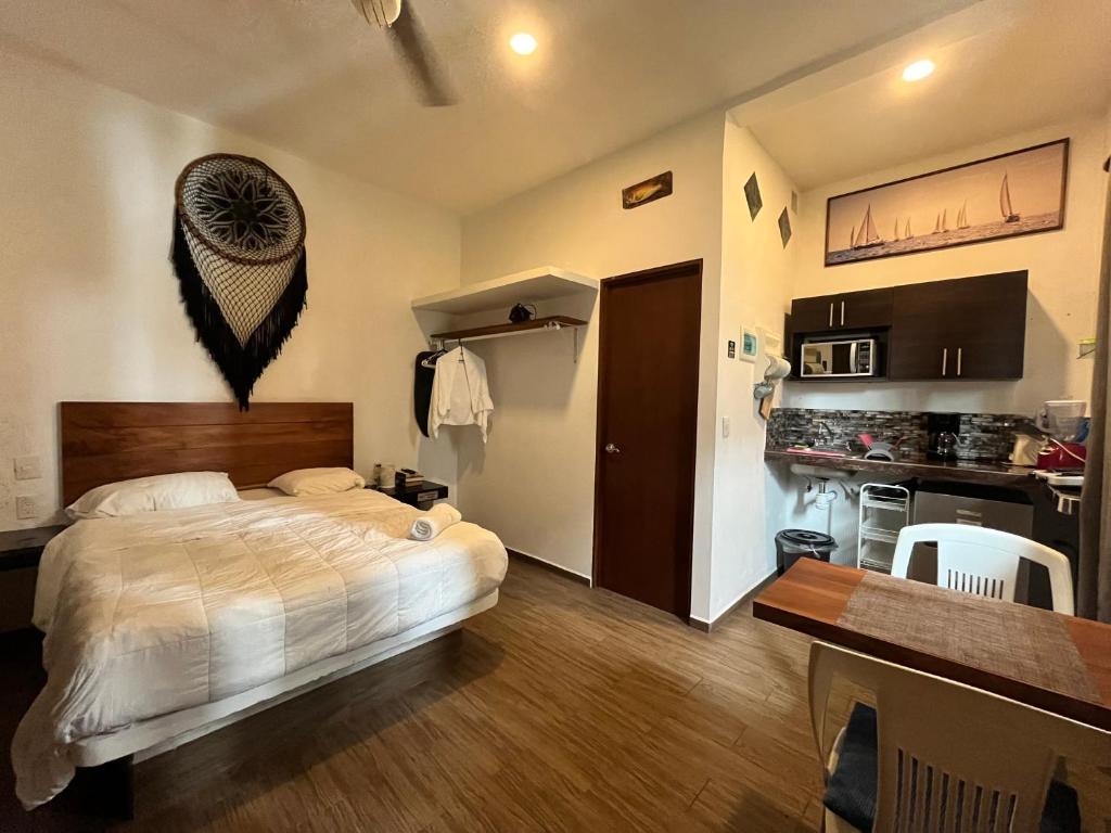 a bedroom with a large bed and a kitchen at Casa Velero Puerto Morelos in Puerto Morelos
