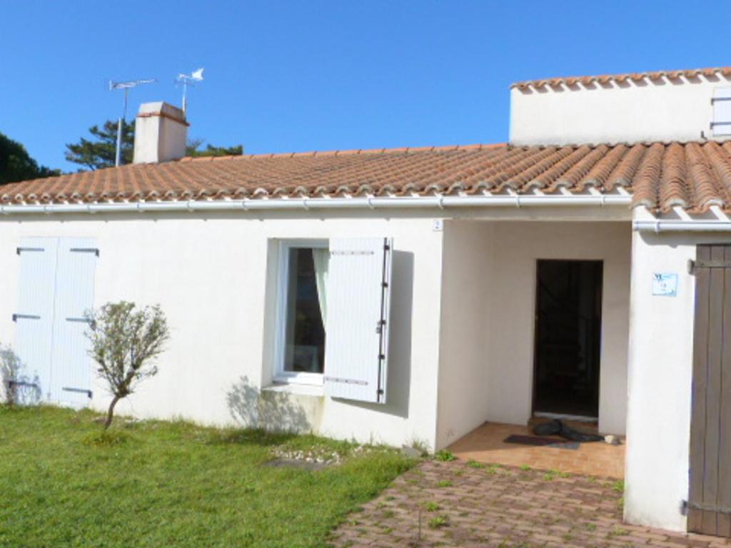 une maison blanche avec un toit rouge dans l'établissement Maison à Barbâtre proche plage, animaux admis - FR-1-823-2, à Barbâtre