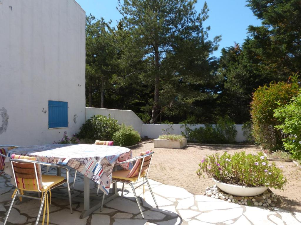 un patio avec une table et des chaises dans une cour dans l'établissement À 200m de la plage, appart. avec jardin pour 4 pers., animaux et parking admis - FR-1-823-20, à La Guérinière