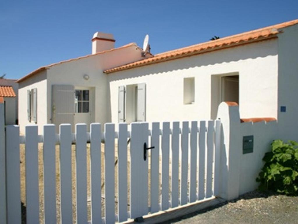 une clôture blanche devant une maison dans l'établissement Maison à L'Épine, proche Plage & Commerces, 4/6 Pers. - FR-1-823-44, à LʼÉpine