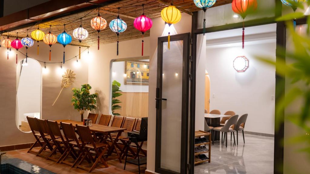 a dining room with a table and chairs and colorful lights at 400m MyKhe Beach Priavate Pool villa in Da Nang
