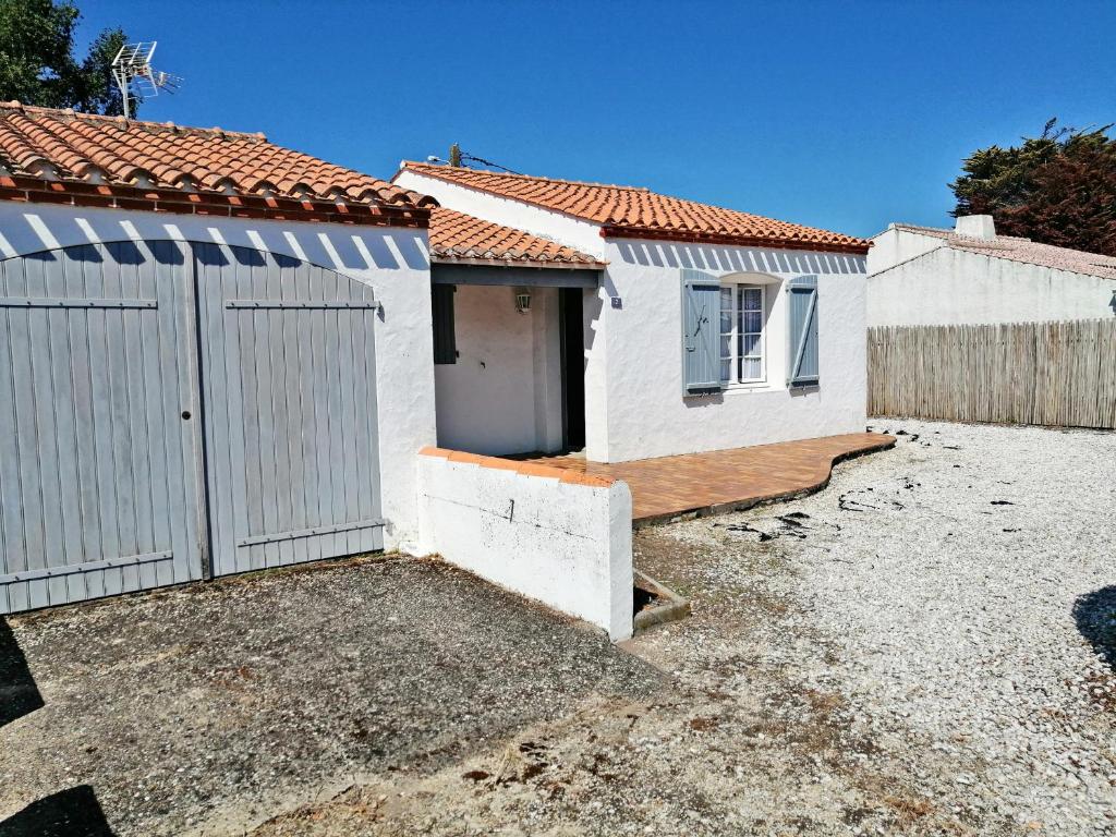 une maison blanche avec un portail et une clôture dans l'établissement Maison à Noirmoutier - Proche plage & forêt - Animaux admis - FR-1-823-65, à Noirmoutier-en-l'lle