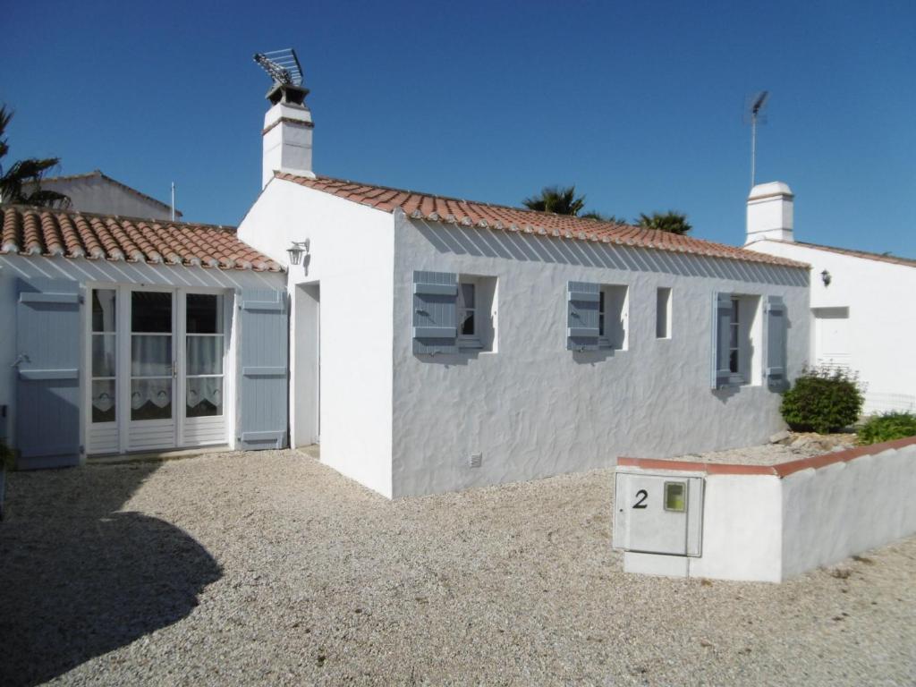une maison blanche avec un garage et une allée dans l'établissement Maison 4/6 pers à Noirmoutier, proche port et plages - FR-1-823-85, à Noirmoutier-en-l'lle