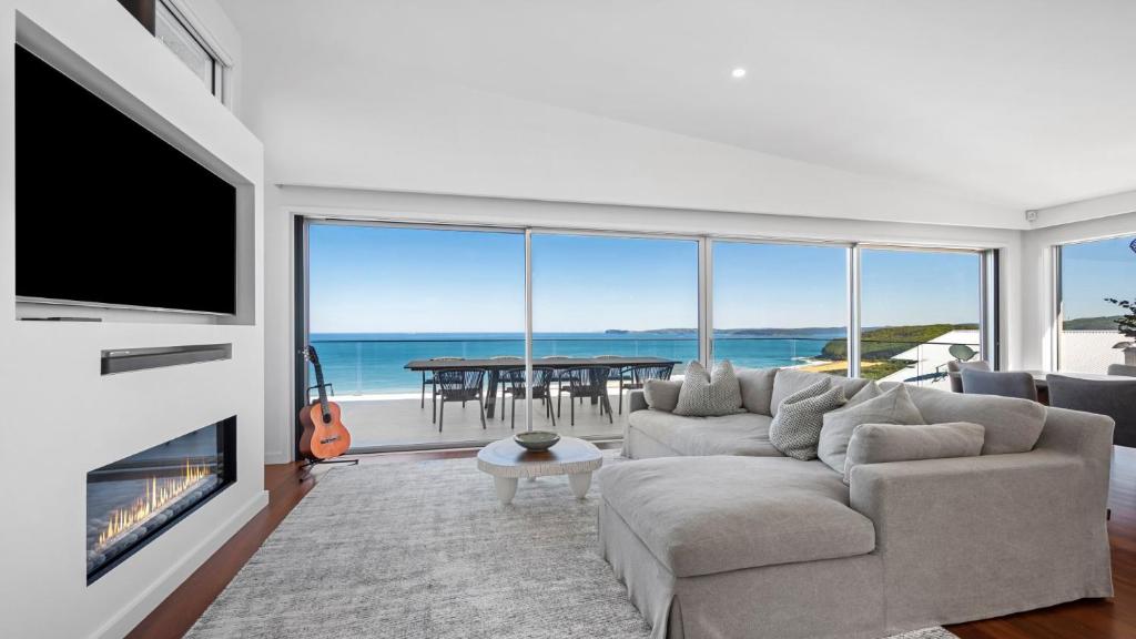 a living room with a couch and a tv and a fireplace at 'Sea Mist' by HolidayCo in Hardys Bay