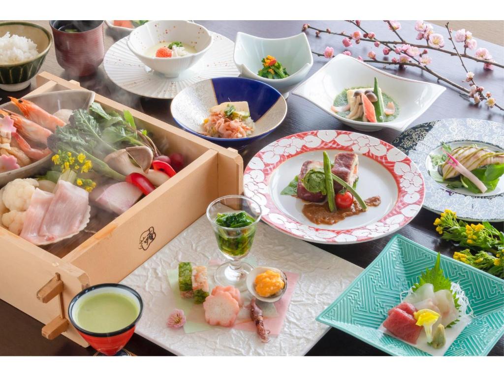 a table with plates of food and bowls of food at Hotel Hanaan in Nikko