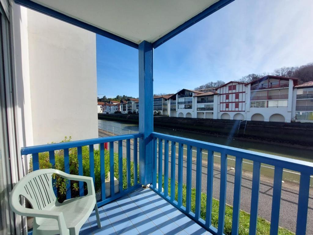 d'un balcon avec une chaise et une vue sur la rivière. dans l'établissement Charmant T2 avec piscine à 2 min de la plage - FR-1-239-1104, à Urrugne