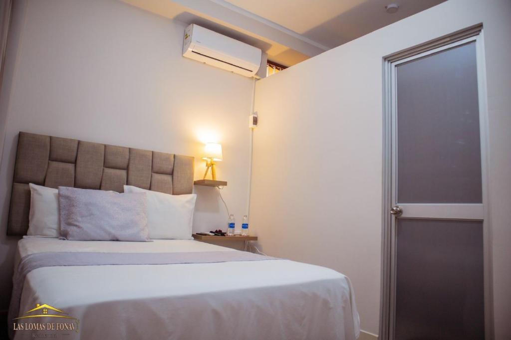 a bedroom with a bed and a door to a room at Las lomas de Fonavi in Tarapoto