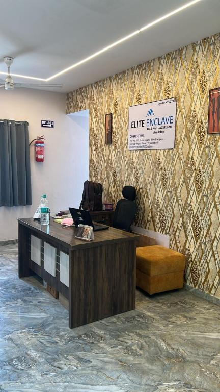 an office with a desk and a sign on a wall at Hotel Elite Enclave in Hyderabad