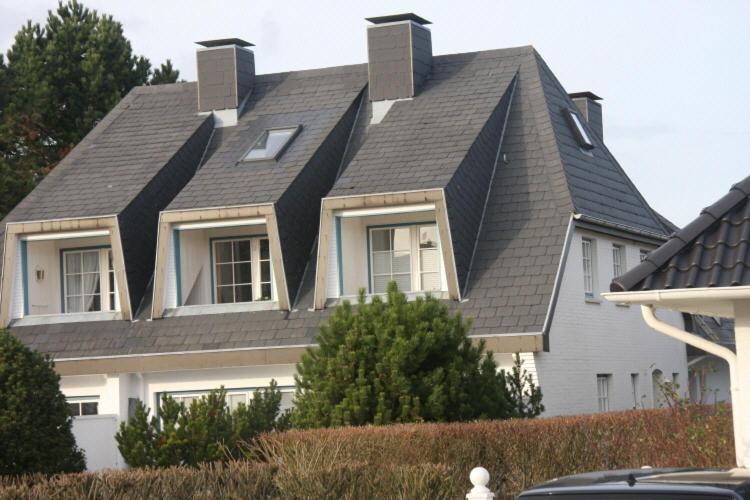 a house with a gambrel roof on top of it at Haus am Watt in Munkmarsch