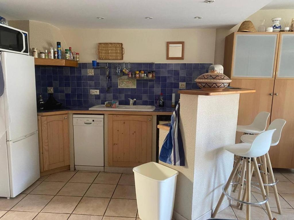 a kitchen with a white refrigerator and blue tiles at F2 Climatisé Proche Cures, Amélie-les-Bains - FR-1-703-208 in Amélie-les-Bains-Palalda