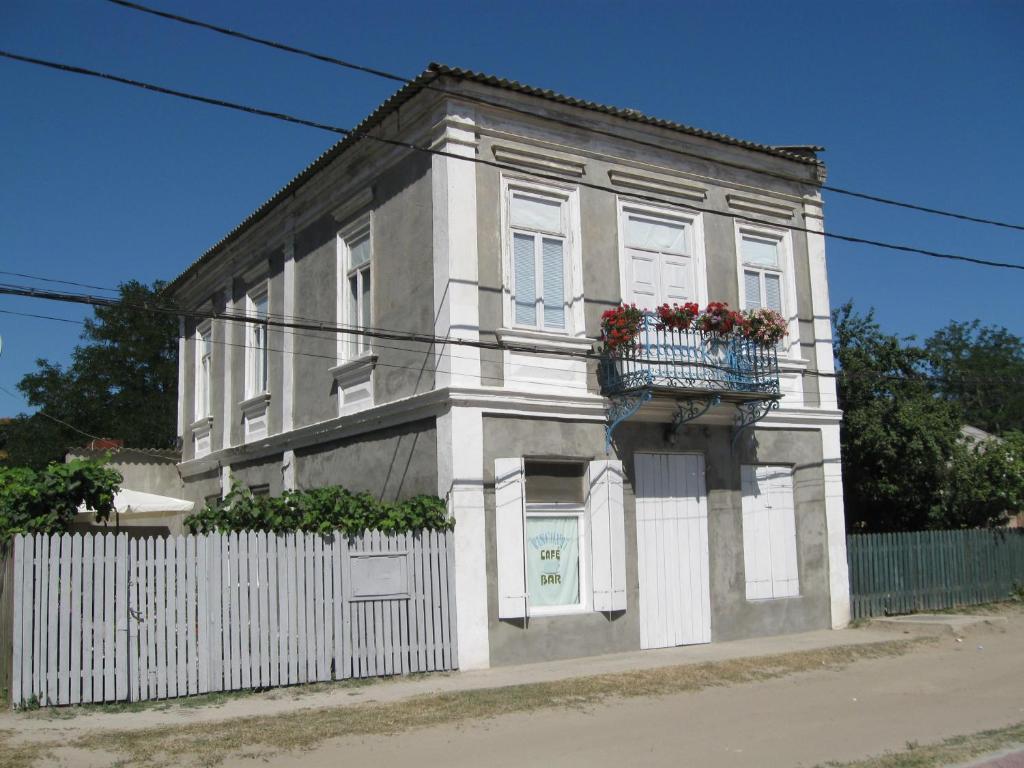 Casa blanca con balcón con flores. en Pensiunea Turistica Visconti en Sfântu Gheorghe