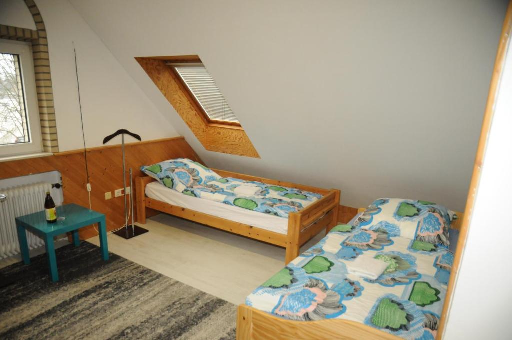 ハノーファーにあるハノーヴァー メッセ ジマーのベッドルーム1室(ベッド2台、テーブル、窓付)