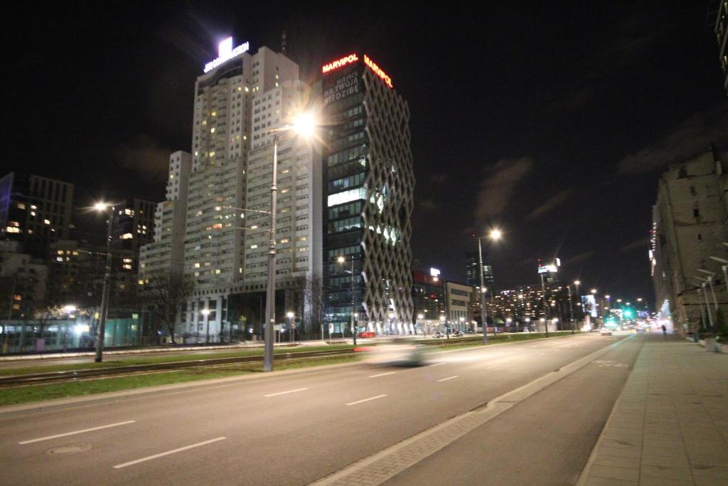 a city street at night with tall buildings at Łucka Residence in Warsaw