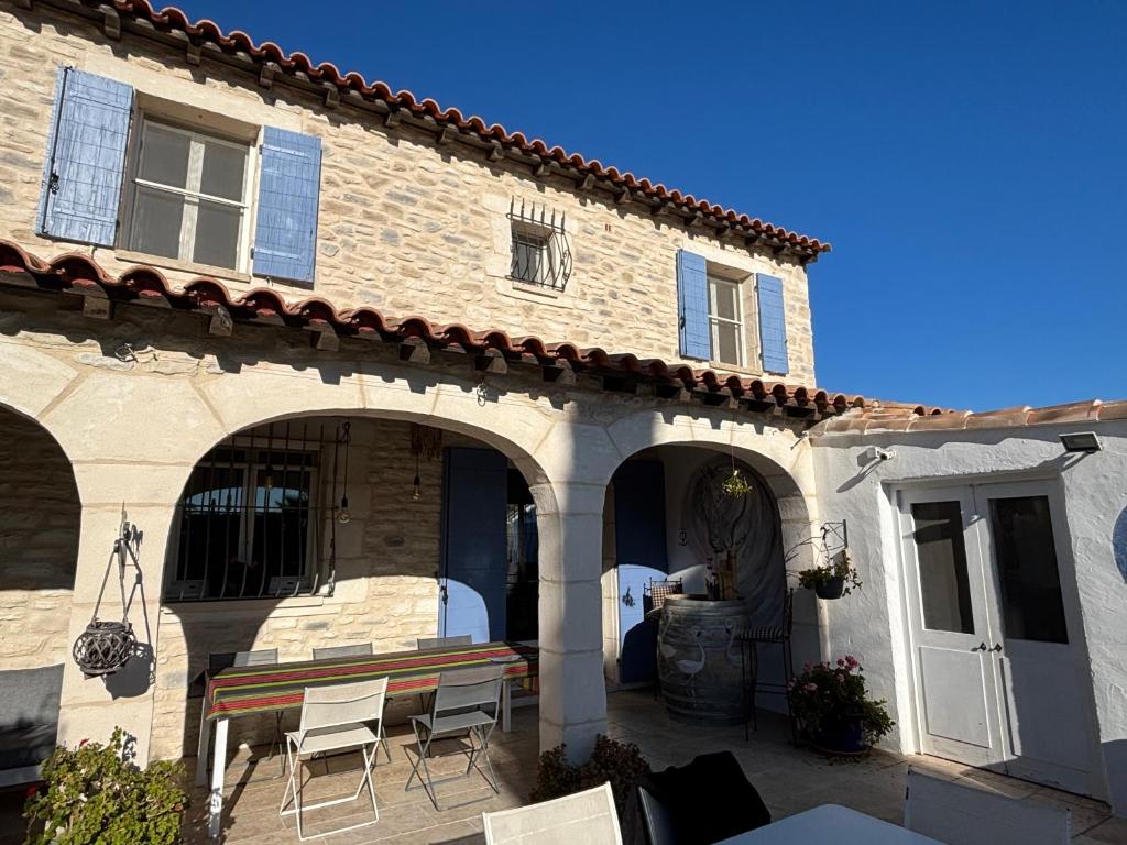 un bâtiment avec une table et des chaises devant lui dans l'établissement Mas du petit Tamaris, à Arles