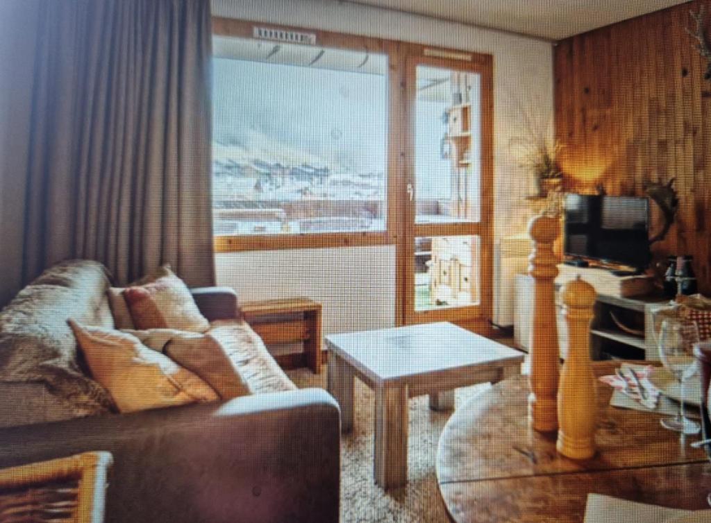 un salon avec un canapé et une table dans l'établissement Valmorel appartement, à Valmorel