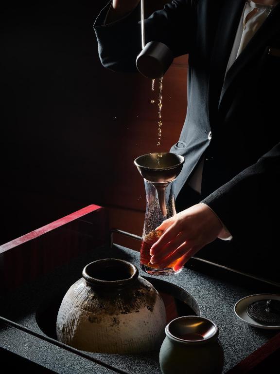 a person is pouring water into a vase at Hyatt Regency Tokyo in Tokyo