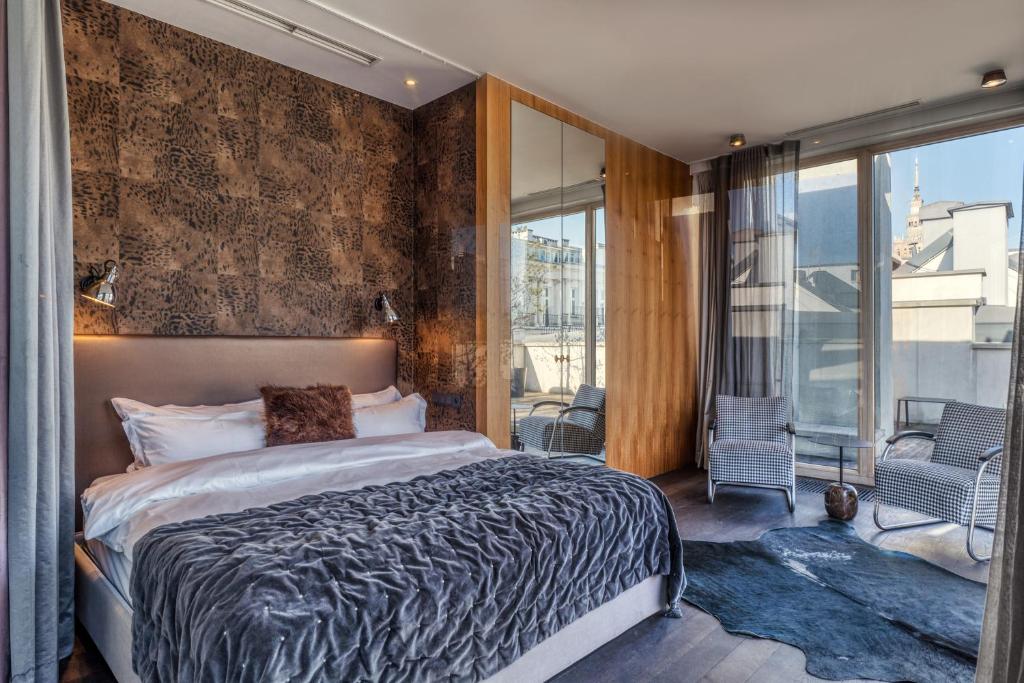 a bedroom with a large bed and a balcony at H15 Boutique Hotel, Warsaw, a Member of Design Hotels in Warsaw