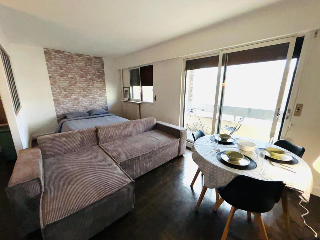 un salon avec un canapé et une table dans l'établissement Superbes Studios av Versailles a Paris 16, à Paris