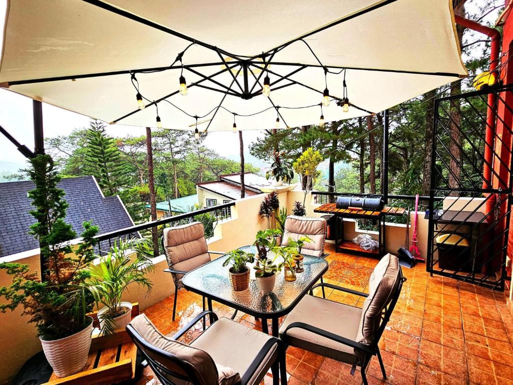 eine Terrasse mit Tisch und Stühlen auf einem Balkon in der Unterkunft Vacation House Camp 7 Baguio Transient 6BR in Baguio City